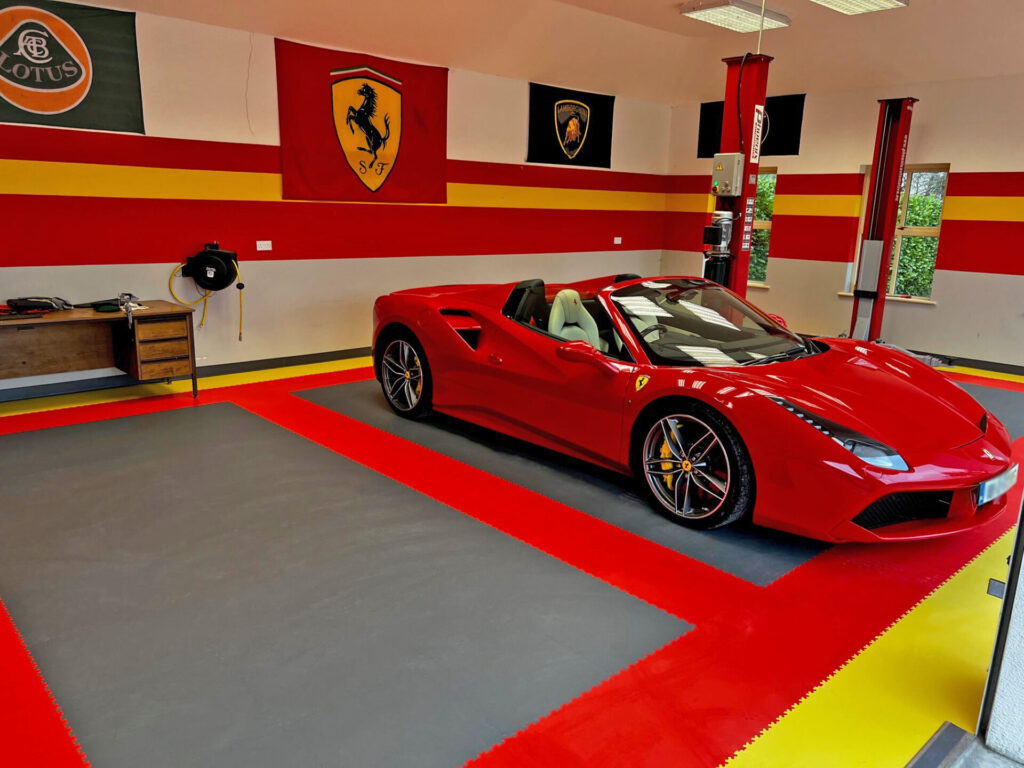 red sports car in garage on red and grey hi-tile floor tiles