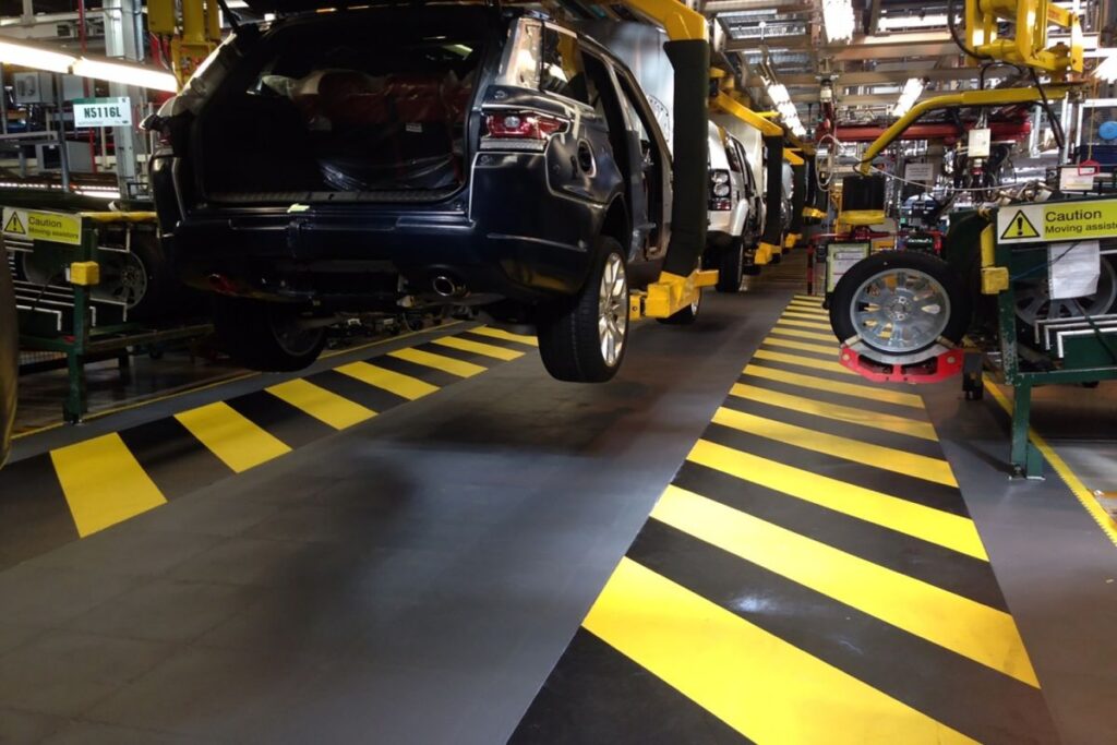 car production line with black and yellow striped hi-tile flooring