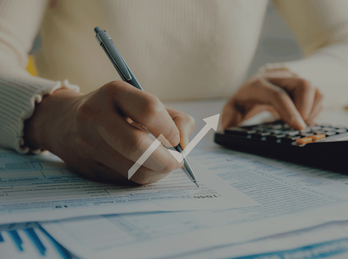 close up of person writing and using calculator